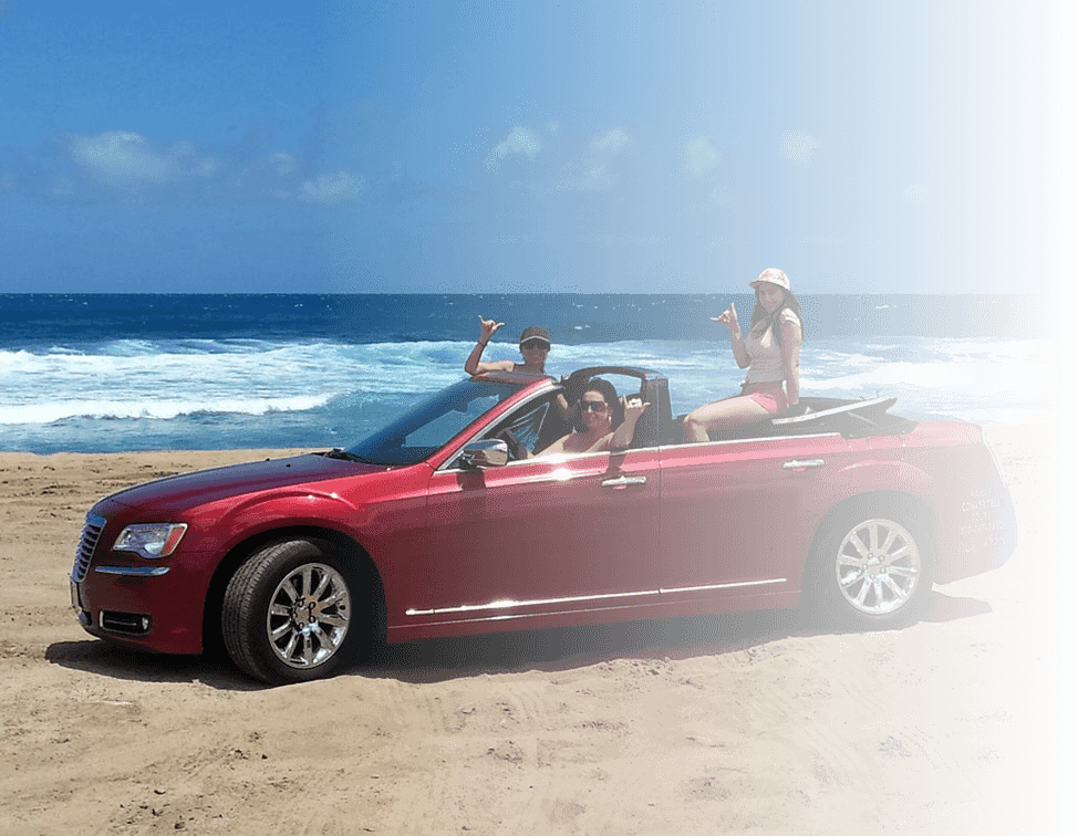 Red convertible on the beach with guests